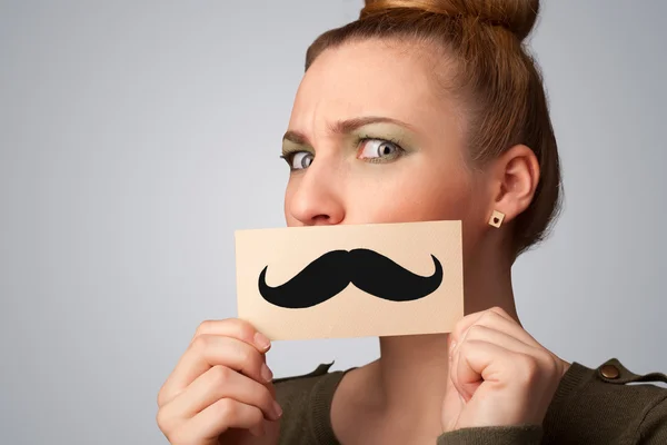 Feliz linda chica sosteniendo papel con bigote dibujo — Foto de Stock