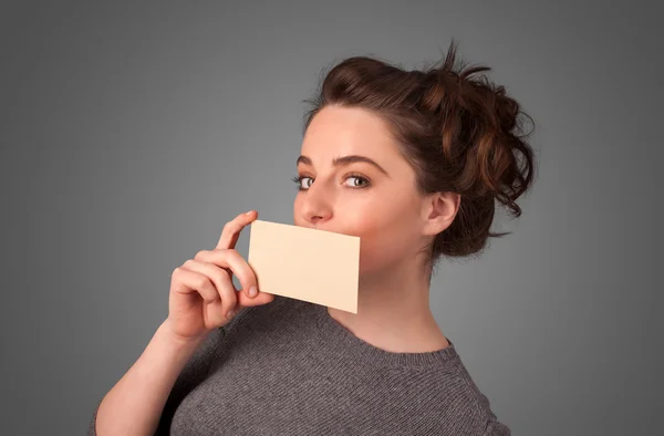 Linda chica sosteniendo la tarjeta blanca en frente de sus labios con spac copia — Foto de Stock