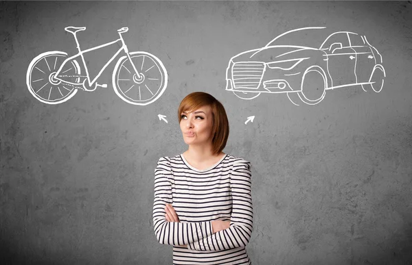 Жінка робить вибір між велосипедом і машиною — стокове фото