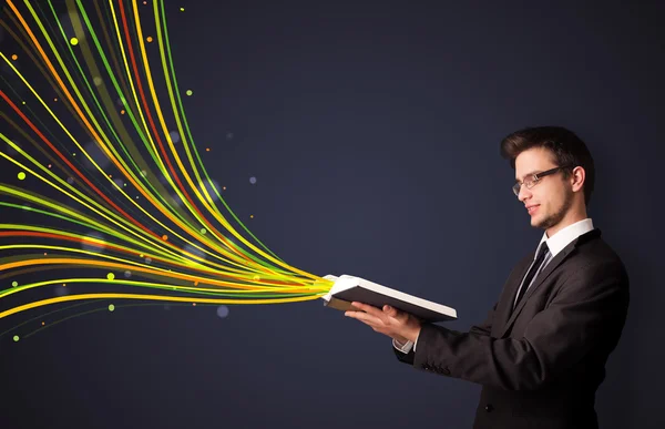 Knappe man lezen van een boek terwijl kleurrijke lijnen zijn coming out — Stockfoto