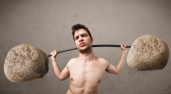 skinny guy lifting large rock stone weights