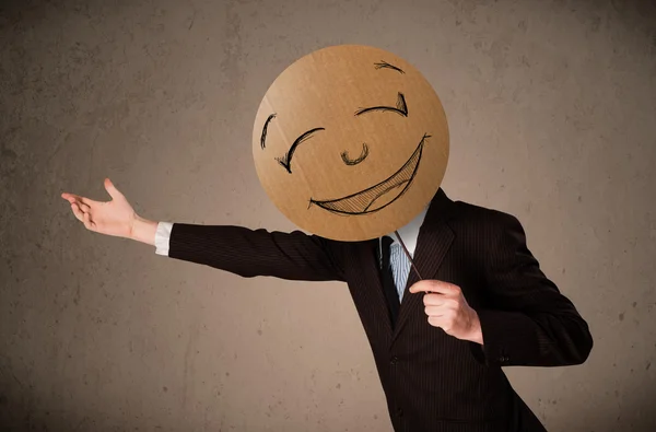 Affärsman som innehar en smiley face styrelse — Stockfoto