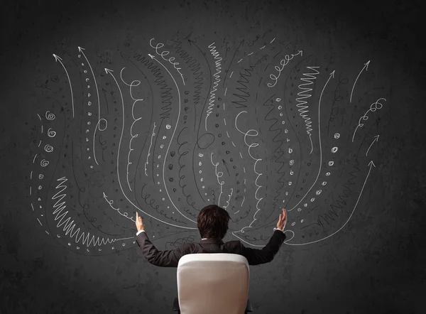 Businessman thinking with sketched arrows in front of a chalkboa — Stock Photo, Image