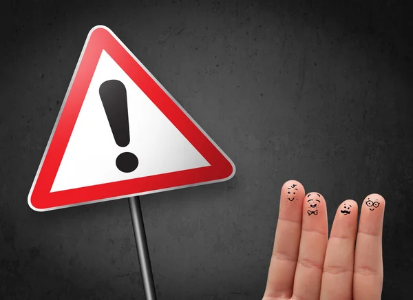 Happy smiley fingers looking at triangle warning sign with excla — Stock Photo, Image