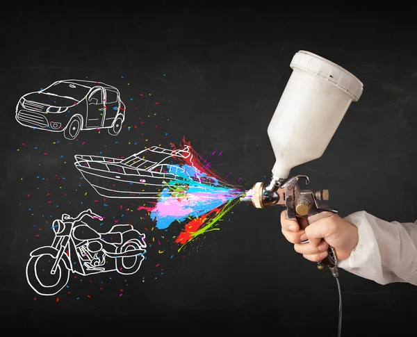 Uomo con aerografo vernice spray con auto, barca e moto disegnare — Foto Stock