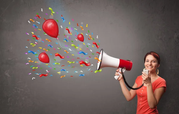 Young girl having fun, shouting into megaphone with balloons — Stock Photo, Image