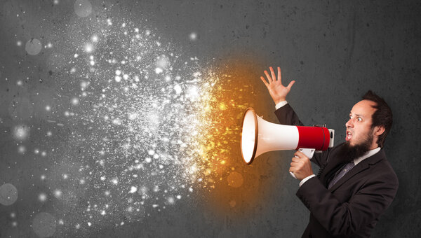 Парень, кричащий в мегафон и пылающие частицы энергии взрываются