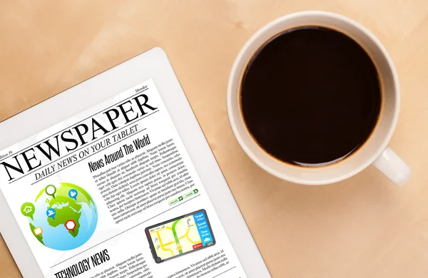 Tablet pc shows news on screen with a cup of coffee on a desk — Stock Photo, Image