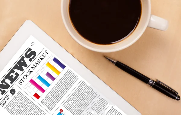 Tablet pc shows news on screen with a cup of coffee on a desk — Stock Photo, Image