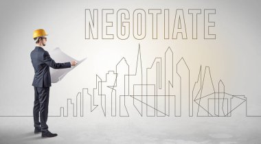 Kasketli bir iş adamı elinde planlar tutuyor