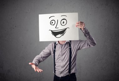 empresario sosteniendo una cartulina con cara sonriente en él en frente 