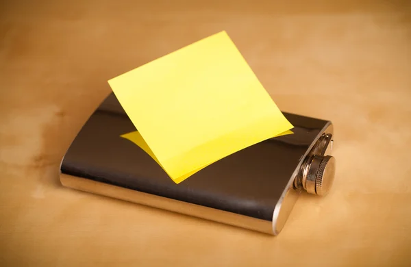 Empty post-it note sticked on hip flask — Stock Photo, Image