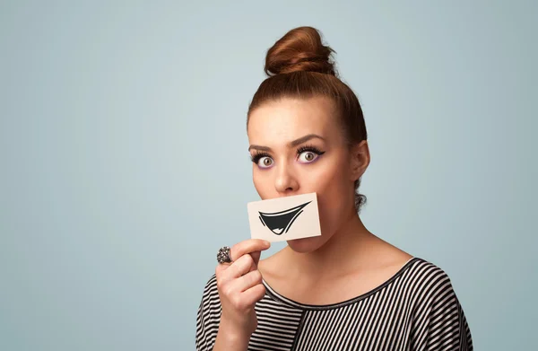 Feliz linda chica sosteniendo papel con divertido dibujo sonriente — Foto de Stock