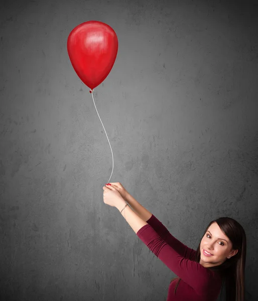 Donna che tiene un palloncino rosso — Foto Stock