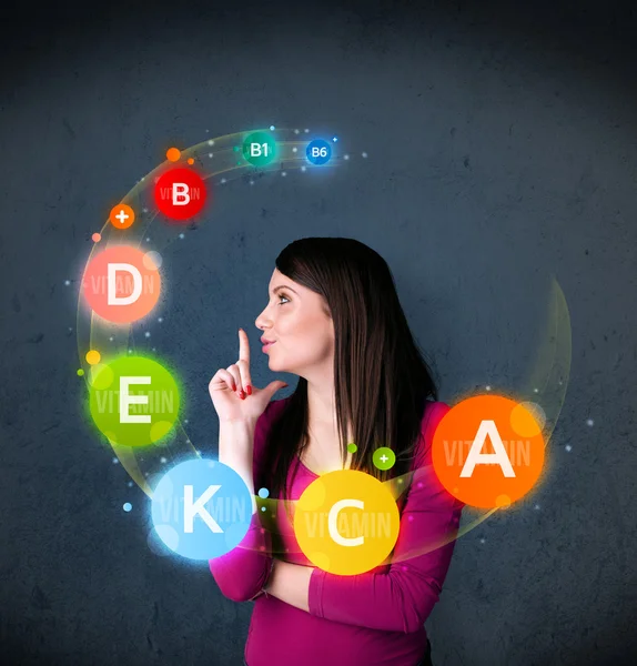 Young woman thinking with vitamins circulation around her head — Stock Photo, Image