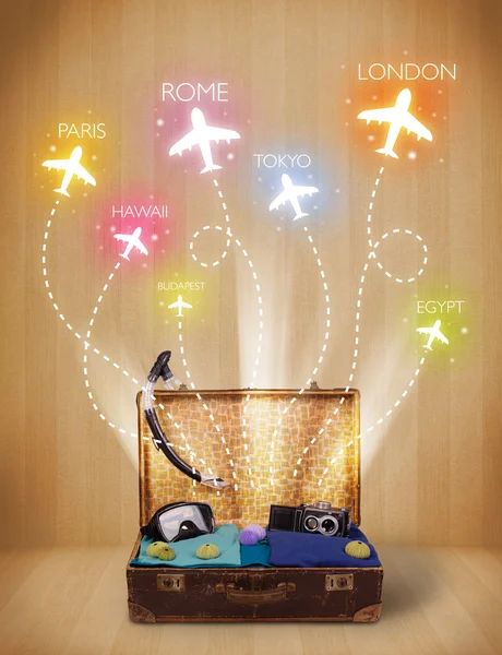 Travel bag with clothes and colorful planes flying out — Stock Photo, Image