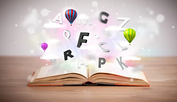 Aufgeschlagenes Buch mit fliegenden 3D-Buchstaben auf Betongrund — Stockfoto