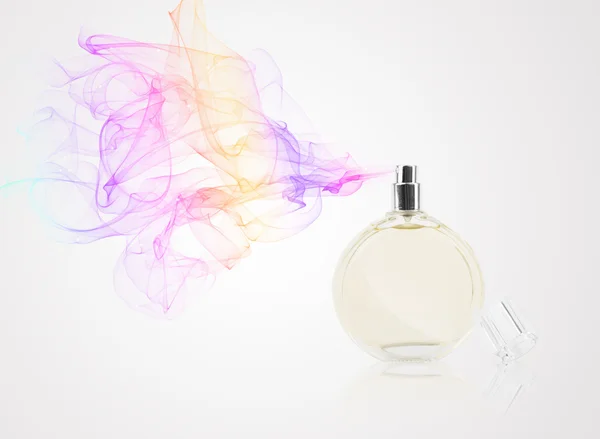 Perfume bottle spraying colored scent — Stock Photo, Image