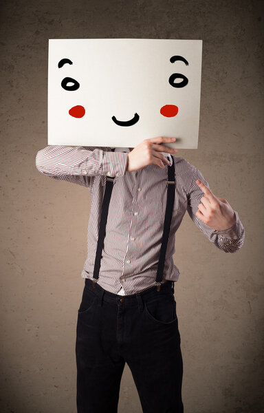 Businessman holding a cardboard with a smiley face on it