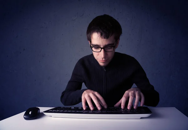 Hacker travaillant avec le clavier sur fond bleu — Photo