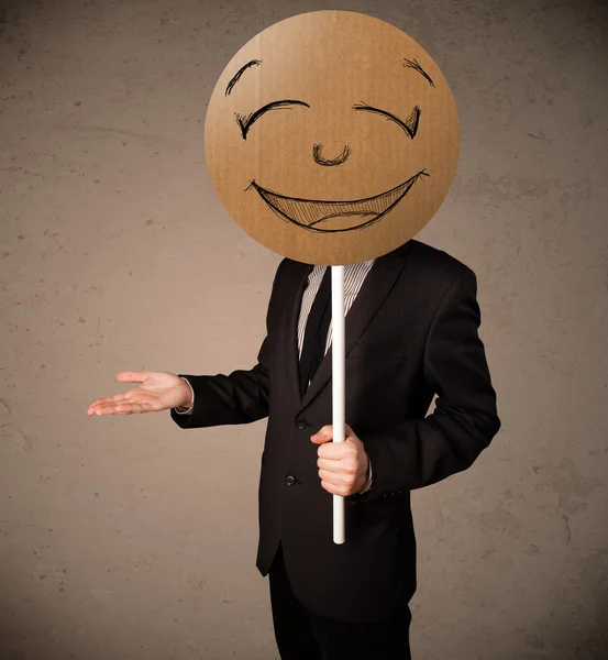 Businessman holding a smiley face board — Stock Photo, Image