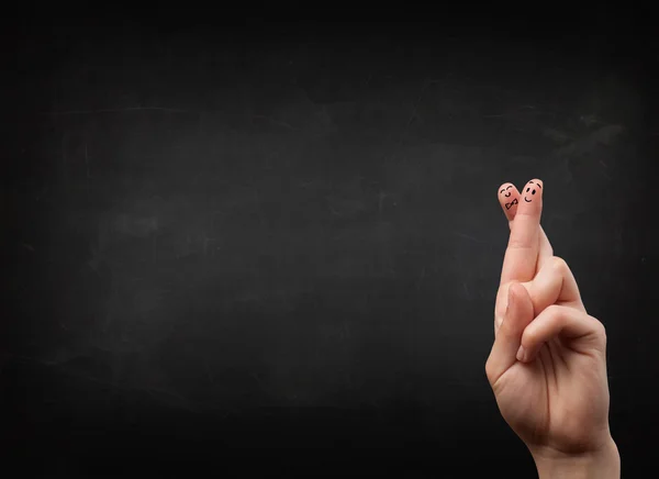 Happy smiley fingers looking at empty black chalboard — Stock Photo, Image