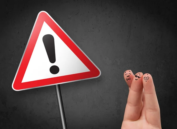 Happy smiley fingers looking at triangle warning sign with excla — Stock Photo, Image