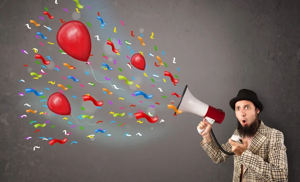 Junger Mann hat Spaß und brüllt mit Luftballons in Megafon — Stockfoto