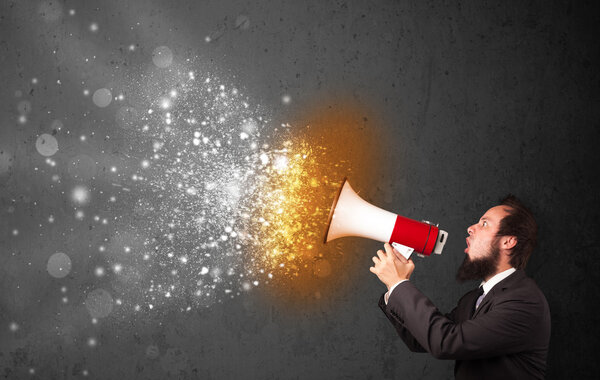 Парень, кричащий в мегафон и пылающие частицы энергии взрываются