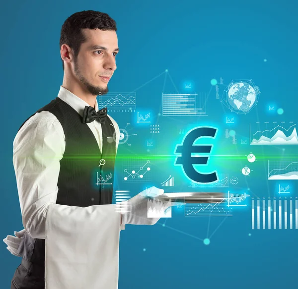 Handsome young waiter in tuxedo holding currency icons on tray — Stock Photo, Image