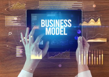 İşletme yazıtlı tableti tutan ellerin yakın çekimi