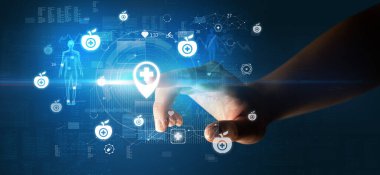 Doktor el, ekranda tıbbi sembollü fütüristik sağlık aygıtı kullanıyor.