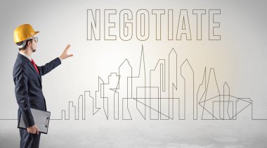 Kasketli bir iş adamı elinde planlar tutuyor