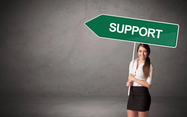 Young business person in casual holding road sign — Stock Photo, Image