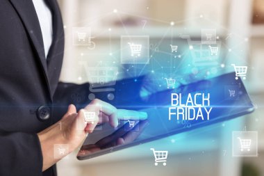 Genç adam tabletle alışveriş yapıyor.