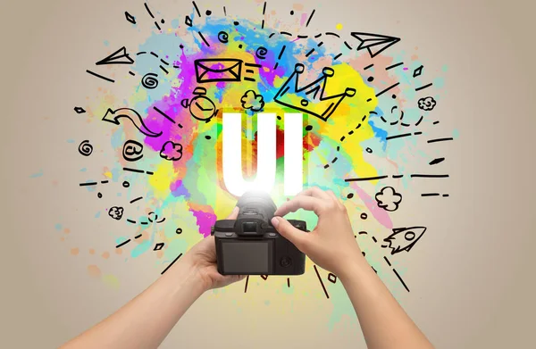 Close-up of a hand holding digital camera with abstract drawing — Stock Photo, Image