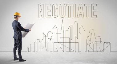 Kasketli bir iş adamı elinde planlar tutuyor