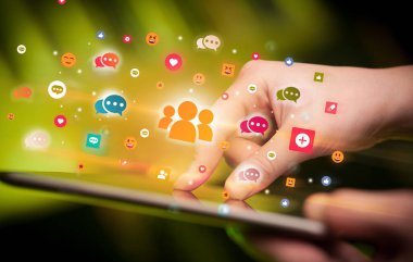 Sosyal medya simgelerine sahip tablet kullanan bir elin yakın plan görüntüsü