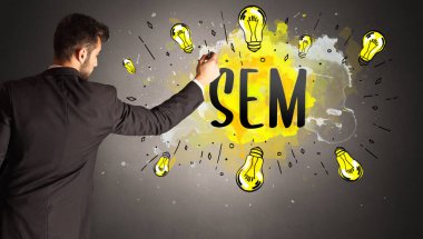 Adam renkli ampul çiziyor.