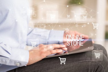 Genç adam tabletle alışveriş yapıyor.