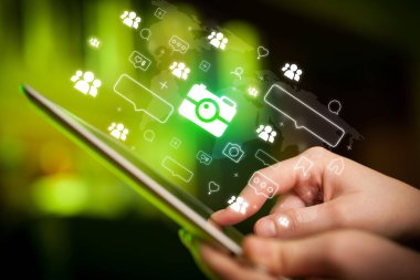 Tablet, sosyal medya kavramı kullanan bir elin yakın plan çekimi