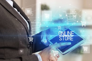 Genç adam tabletle alışveriş yapıyor.