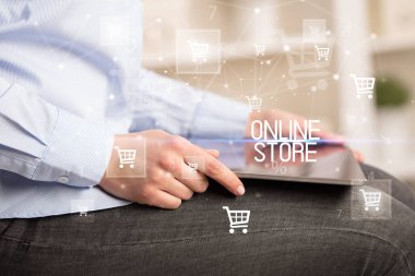 Genç adam tabletle alışveriş yapıyor.