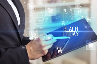 Genç adam tabletle alışveriş yapıyor.