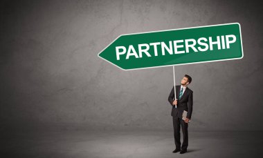 Gündelik trafik levhasındaki genç iş adamı.