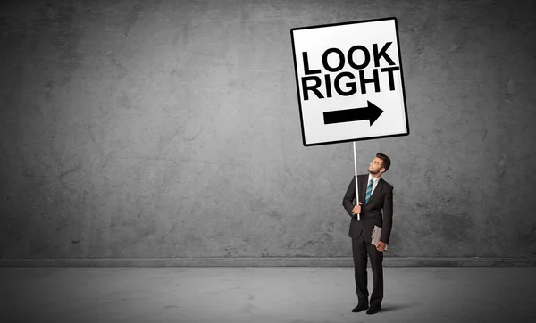 Business person holding a traffic sign — Stock Photo, Image