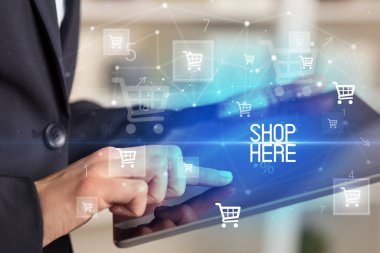 Genç adam tabletle alışveriş yapıyor.