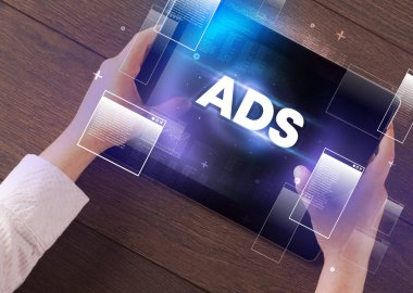 ADS kısaltması, modern teknoloji konsepti olan bir tabletin el ele tutuşması.