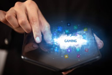 İş adamı katlanabilir bir akıllı telefon tutuyor. Oyun yazıtları ve teknoloji konsepti var.