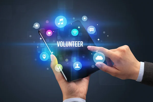 ボランティアの碑文 ソーシャルメディアの概念と折り畳み式のスマートフォンを保持ビジネスマン — ストック写真